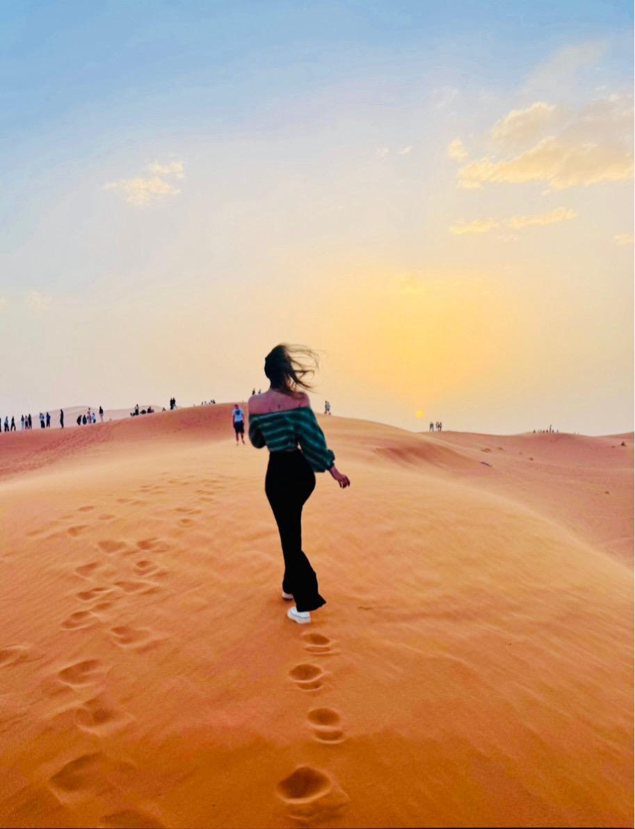Viajera subiendo una duna del Erg Chebbi a la luz dorada