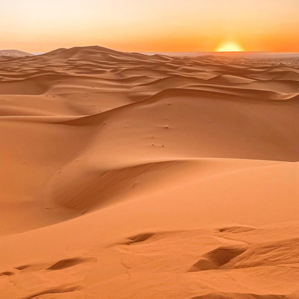Últimas luces del día sobre las dunas naranjas del Sahara