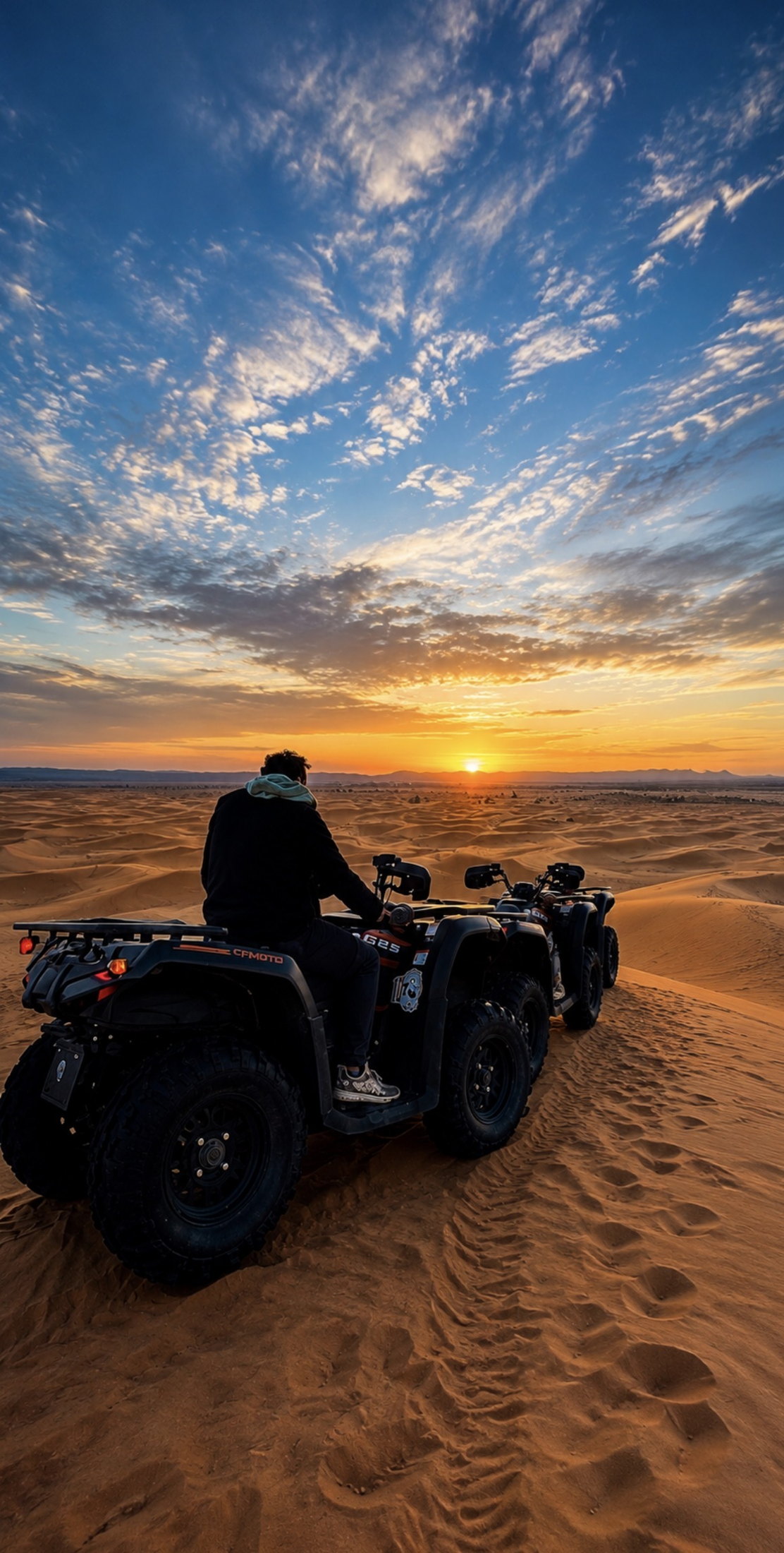 Quads parados sobre una duna mientras se pone el sol en el desierto de Merzouga